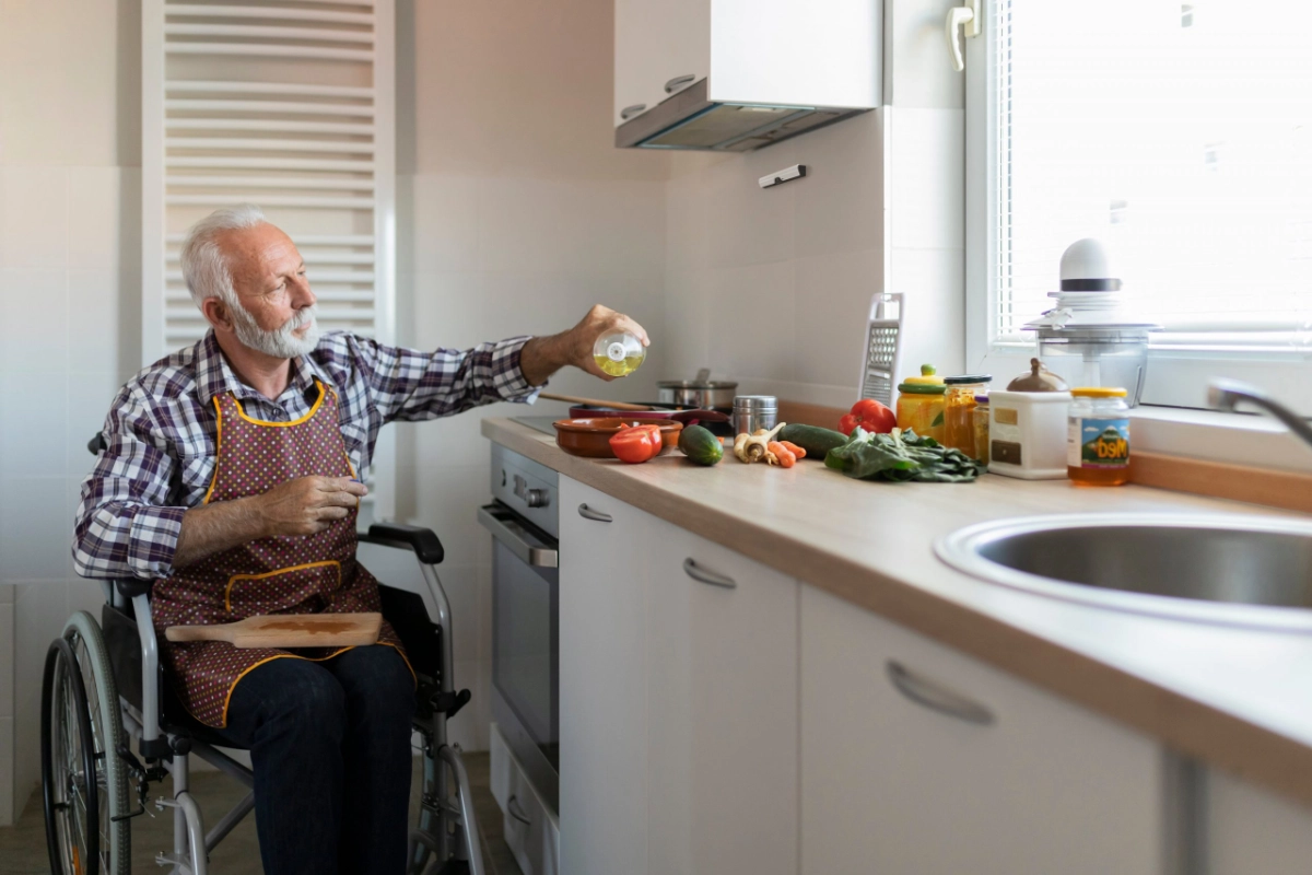 A man in a wheelchair cooking safely with Airis stove guard installed