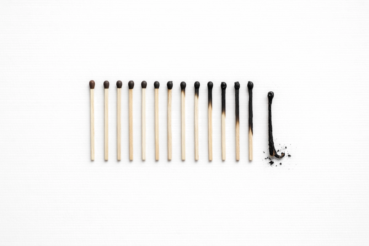 a series of matchsticks burnt to different amounts on a white paper background